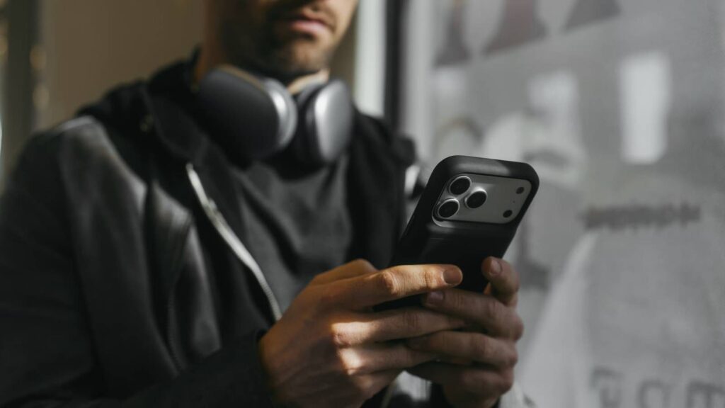 a person using a juice back on an iphone with headphones on.jpg