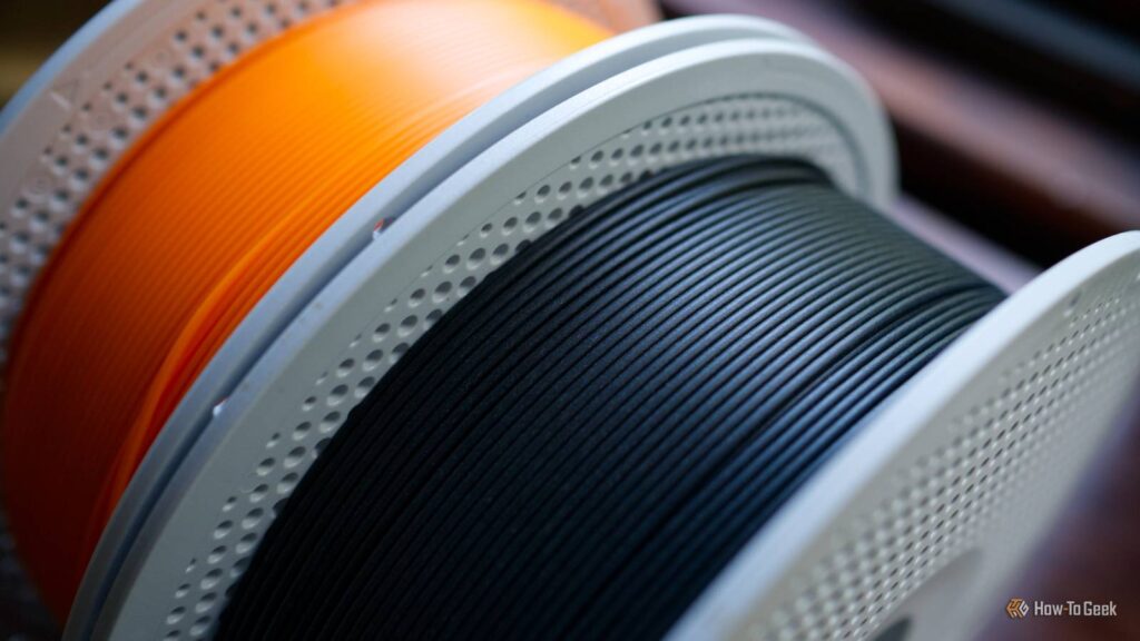 a roll of black pla matte and basic pla orange 3d printer filament.jpg