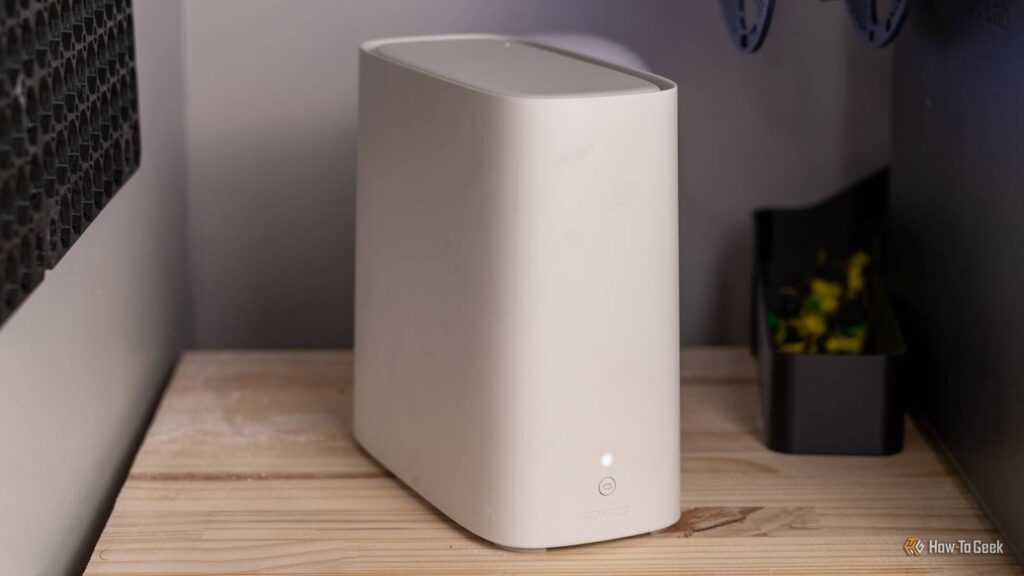 Forestall the usage of your router's default settings (trade those 3 issues instantly) a white at t bgw320 wi fi 6 router on a wooden shelf between two desktop towers.jpg