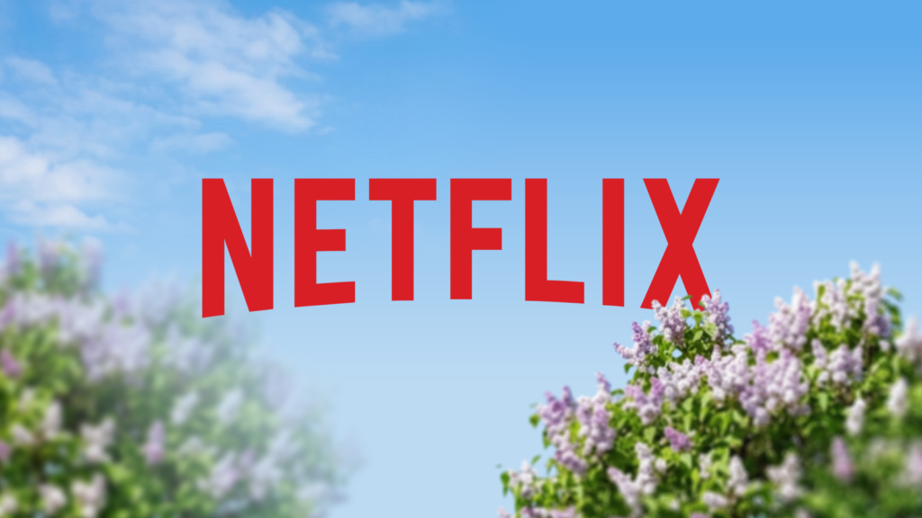 netflix logo against a clear blue sky with blurred purple flowers.png