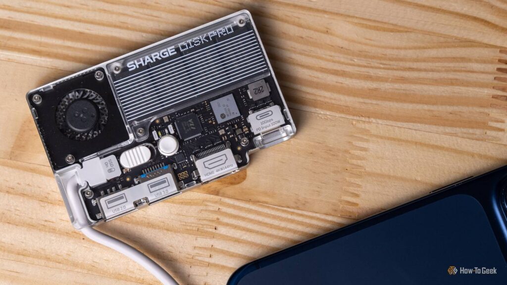 the transparent sharge disk pro connected to the back of an iphone 17 pro on a wooden table.jpg