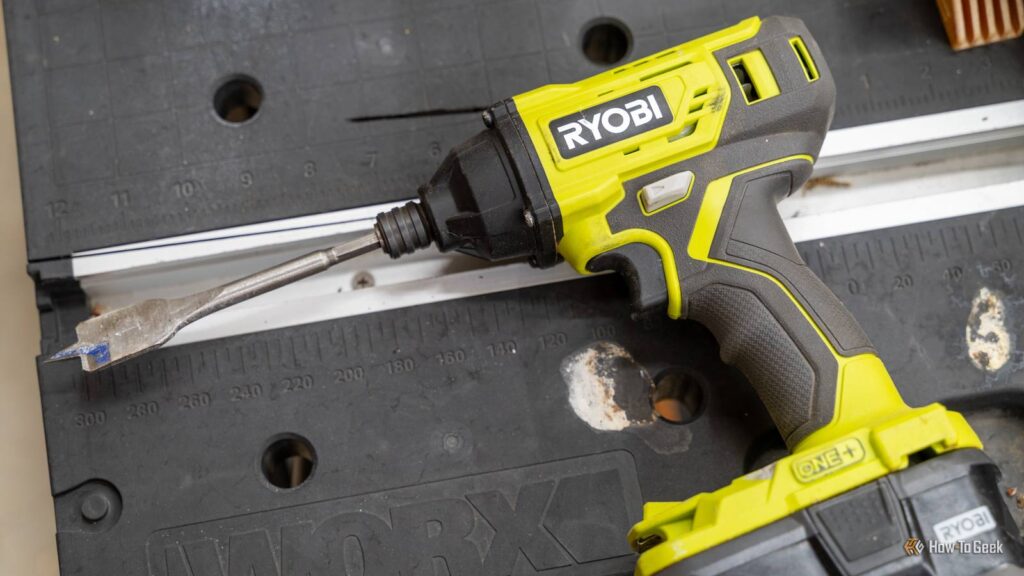 close up of a ryobi one plus 18v impact driver with a spade bit attached.jpg