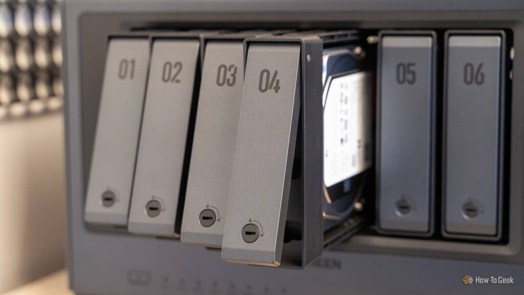drive trays fanned out from the ugreen idx6011 pro nas showing the tool free tray design and an inst.jpeg