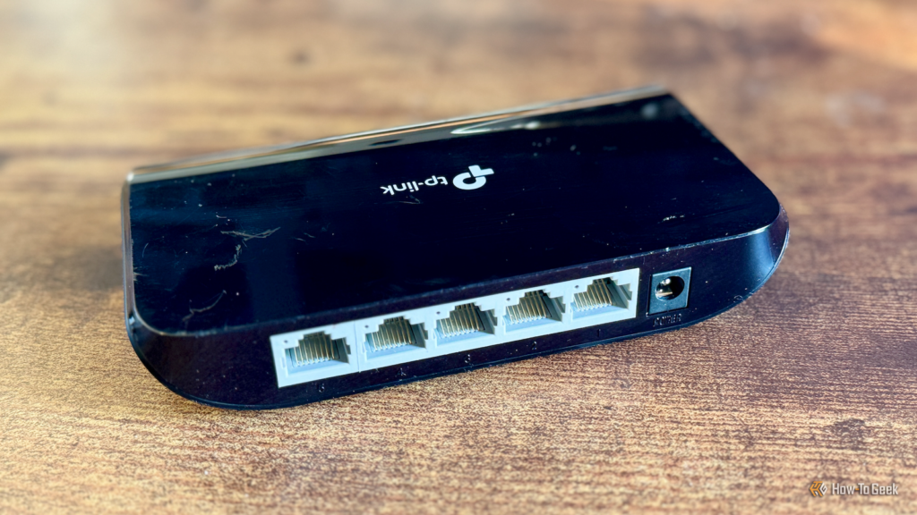 the rear of a 5 port tp link network switch on a desk.png