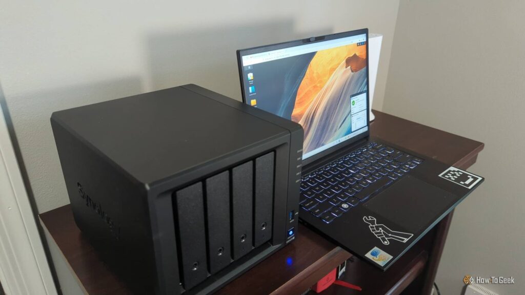 the synology ds425 nas next to a laptop comupter showing the dsm operating system 2.jpg